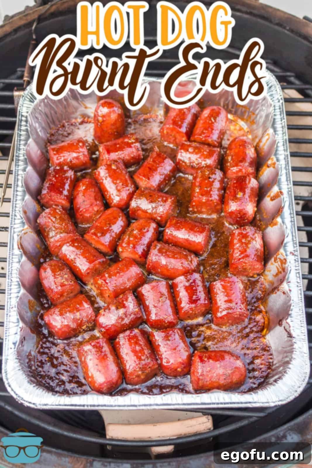 An aluminum tray of Smoked Hot Dog Burnt Ends, rich with sauce and seasoning.