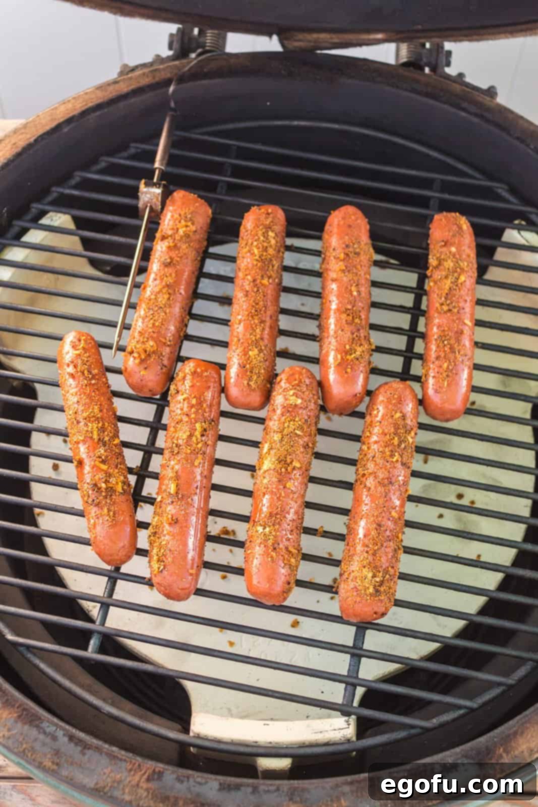 Seasoned hot dogs placed directly on a grill grate in a smoker.