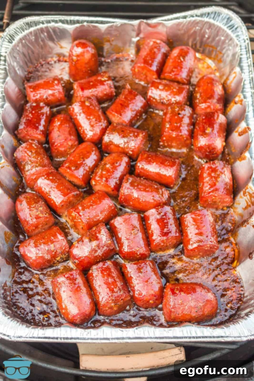 An aluminum foil pan of Hot Dog Burnt Ends, caramelized and ready to serve.