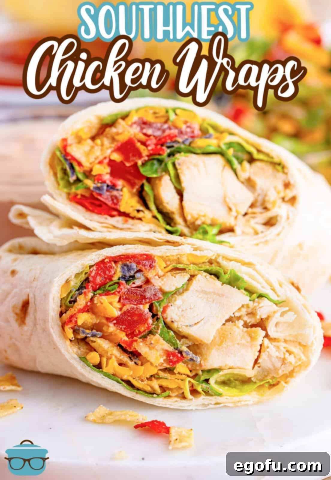 A perfectly cut Southwest Chicken Wrap, revealing layers of chicken, cheese, lettuce, and sauce.