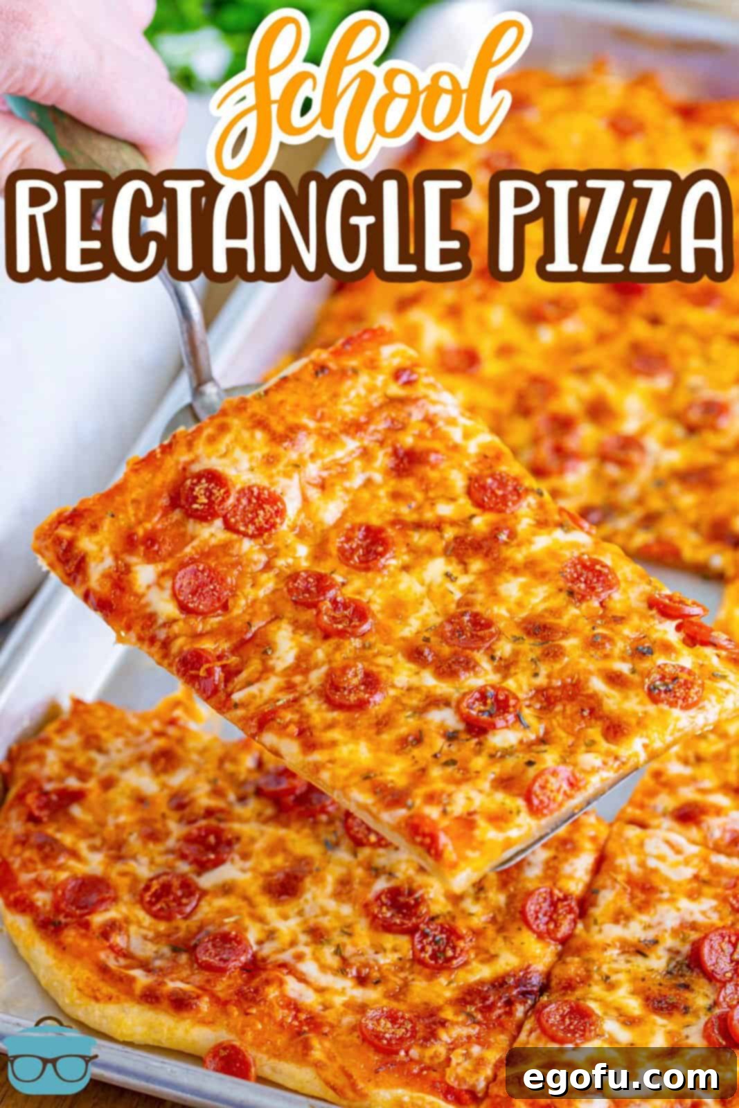 A slice of Rectangle School Pizza being held over the rest of the pizza pie, showing its golden crust and melted cheese.