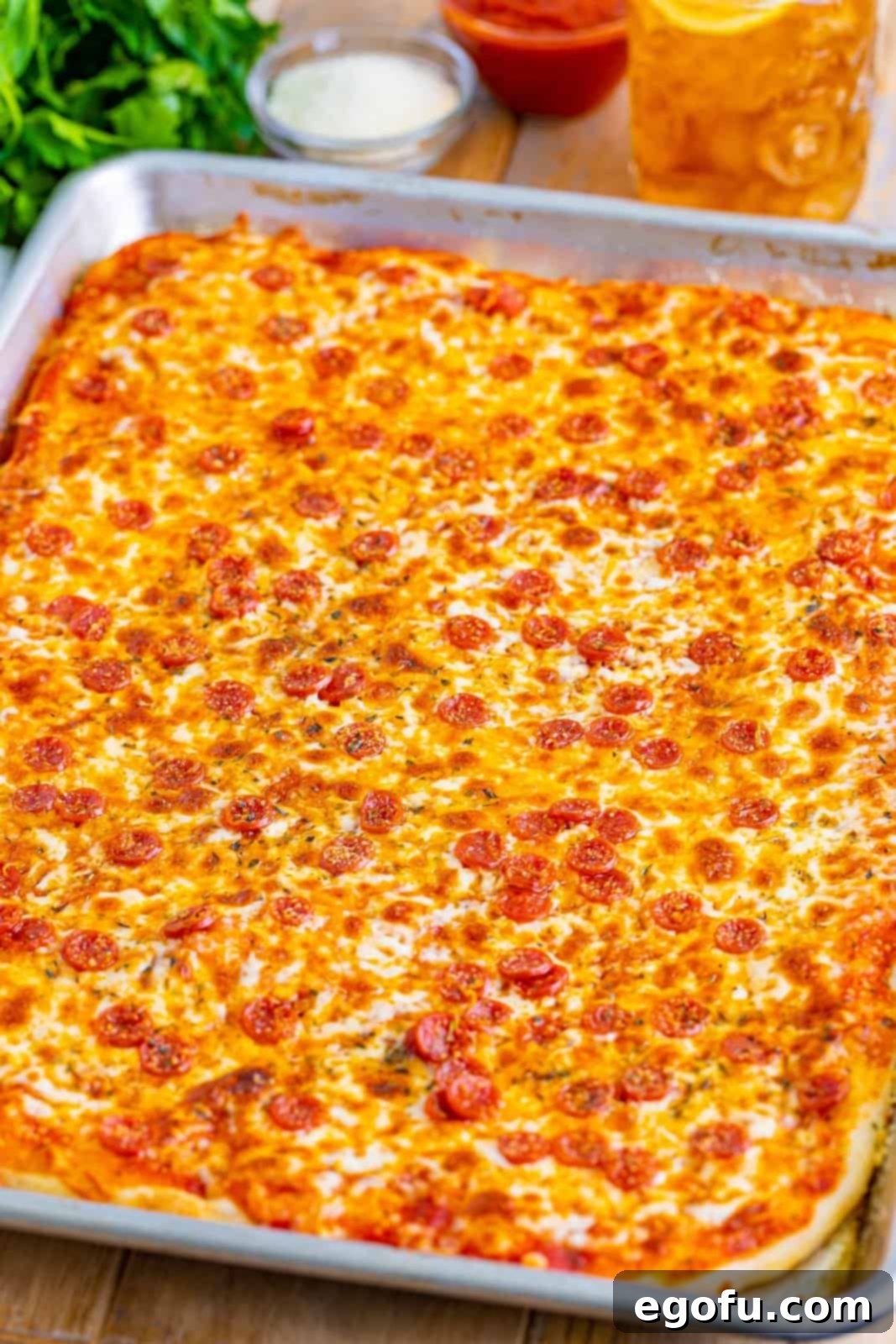 A freshly baked, golden-brown sheet pan of homemade school pizza, glistening with melted cheese and crispy pepperoni.