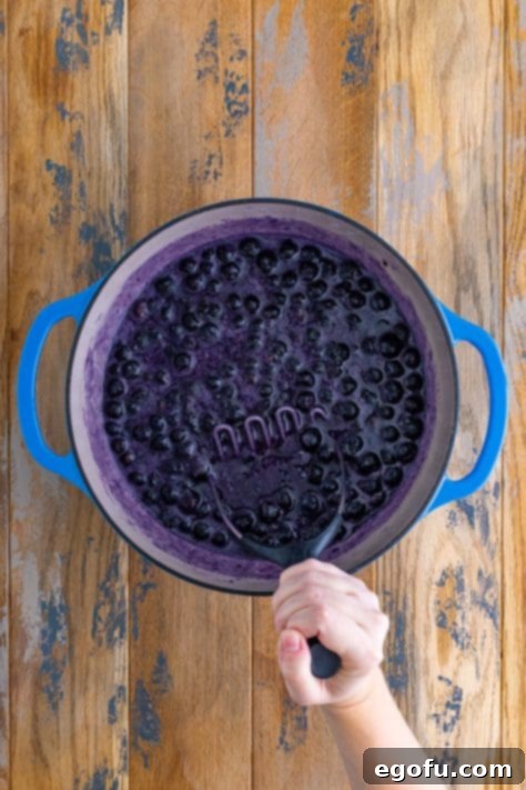 A potato mashed mashing berries for jam.