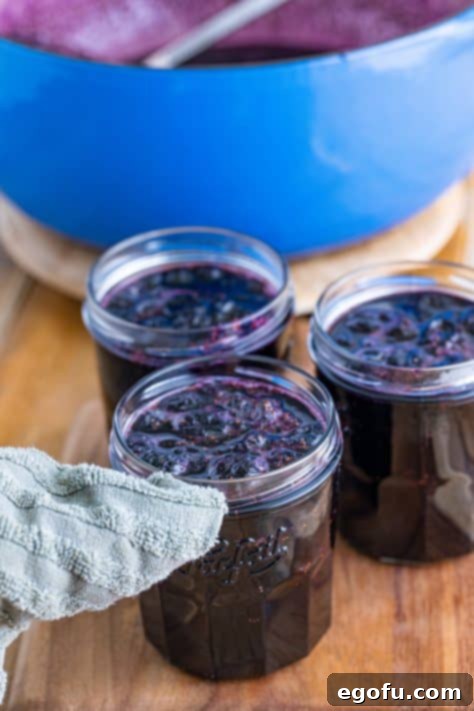 Wiping off the edge of a blueberry jam jar.