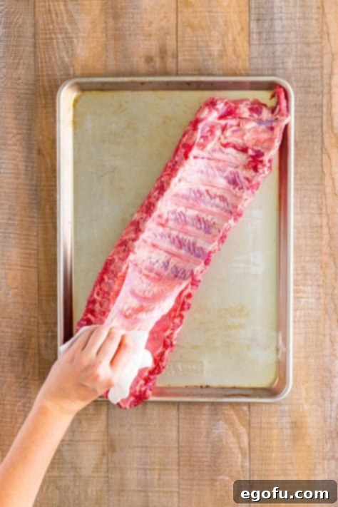 Pulling the membrane off a rack of ribs.