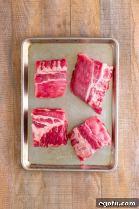 Four chunks of ribs on a sheet pan.