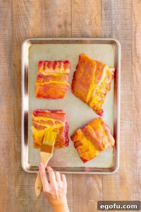 A brush rubbing mustard all over ribs.