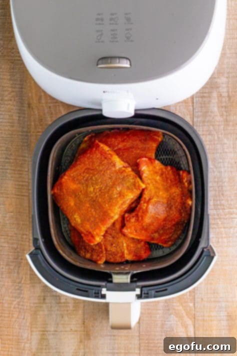 Seasoned ribs in a pile in an Air Fryer basket.