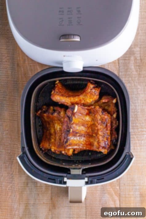 chicken thighs shown upside down in air fryer basket.