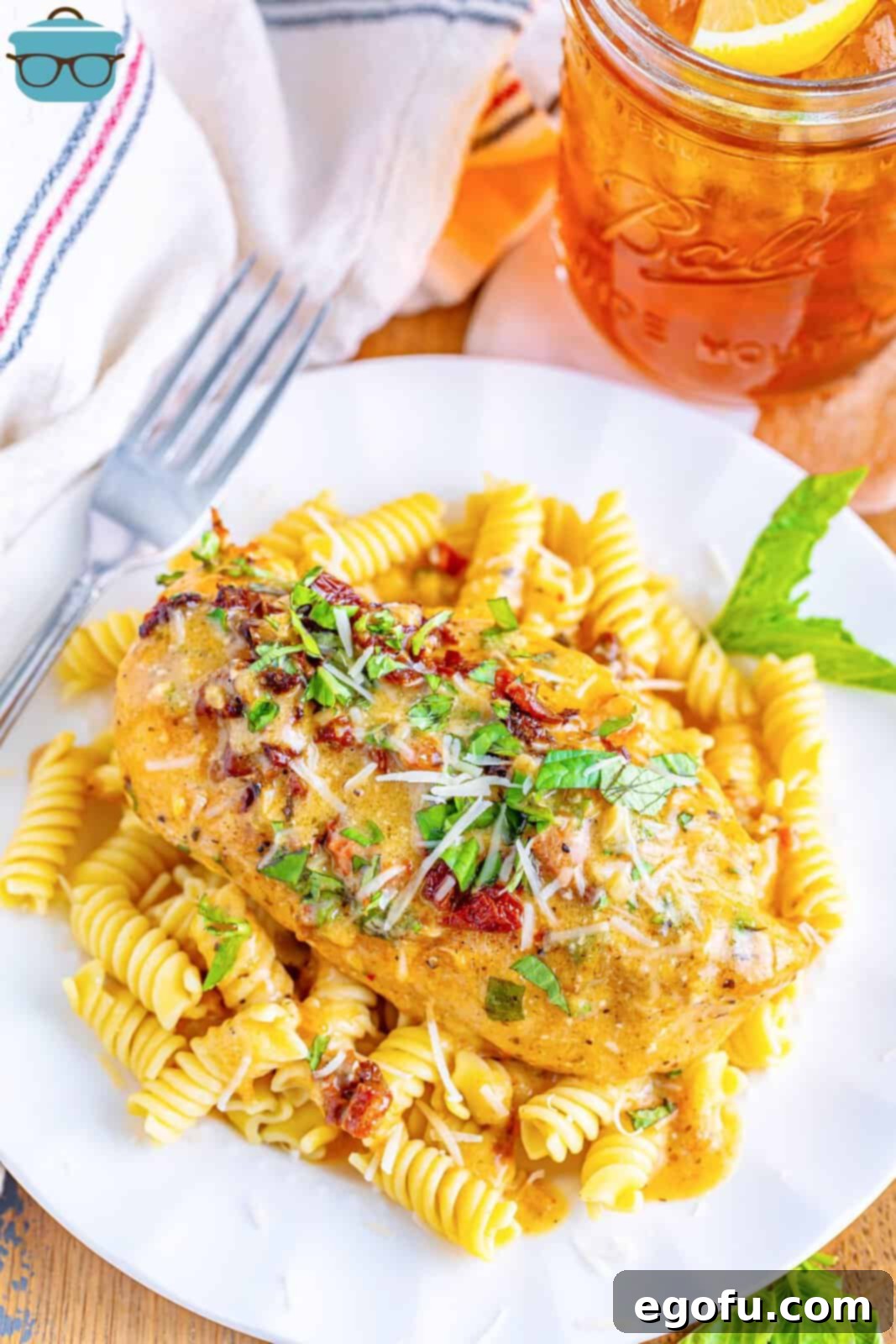 Slow Cooker Love Potion Chicken 2 Marry Me Chicken over a bed of pasta on a plate.