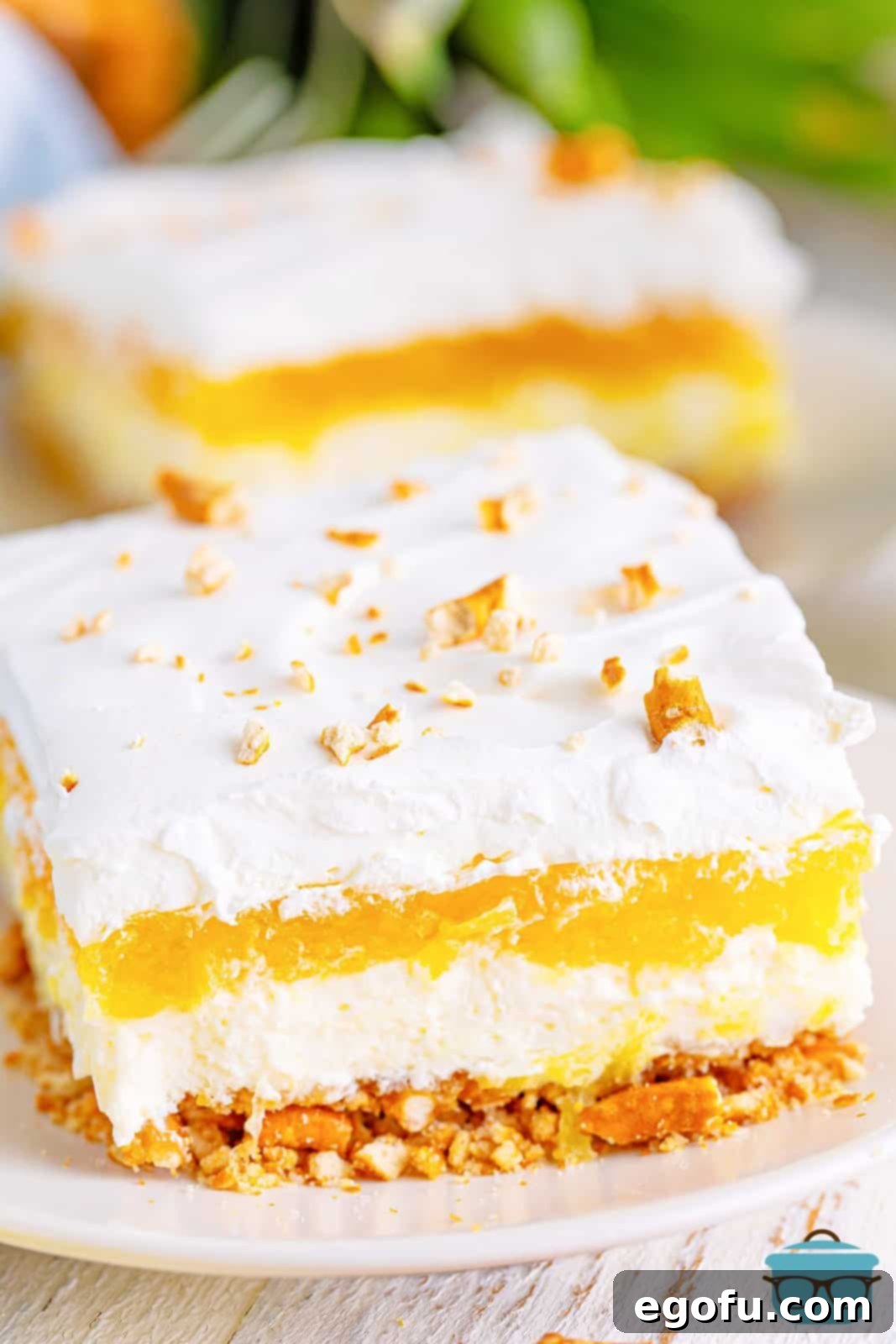 A plate with a slice of pineapple pretzel salad.