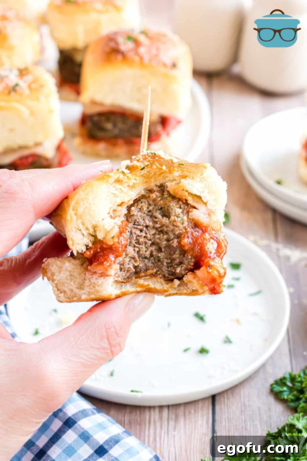 An individual Meatball slider with a bite taken out.