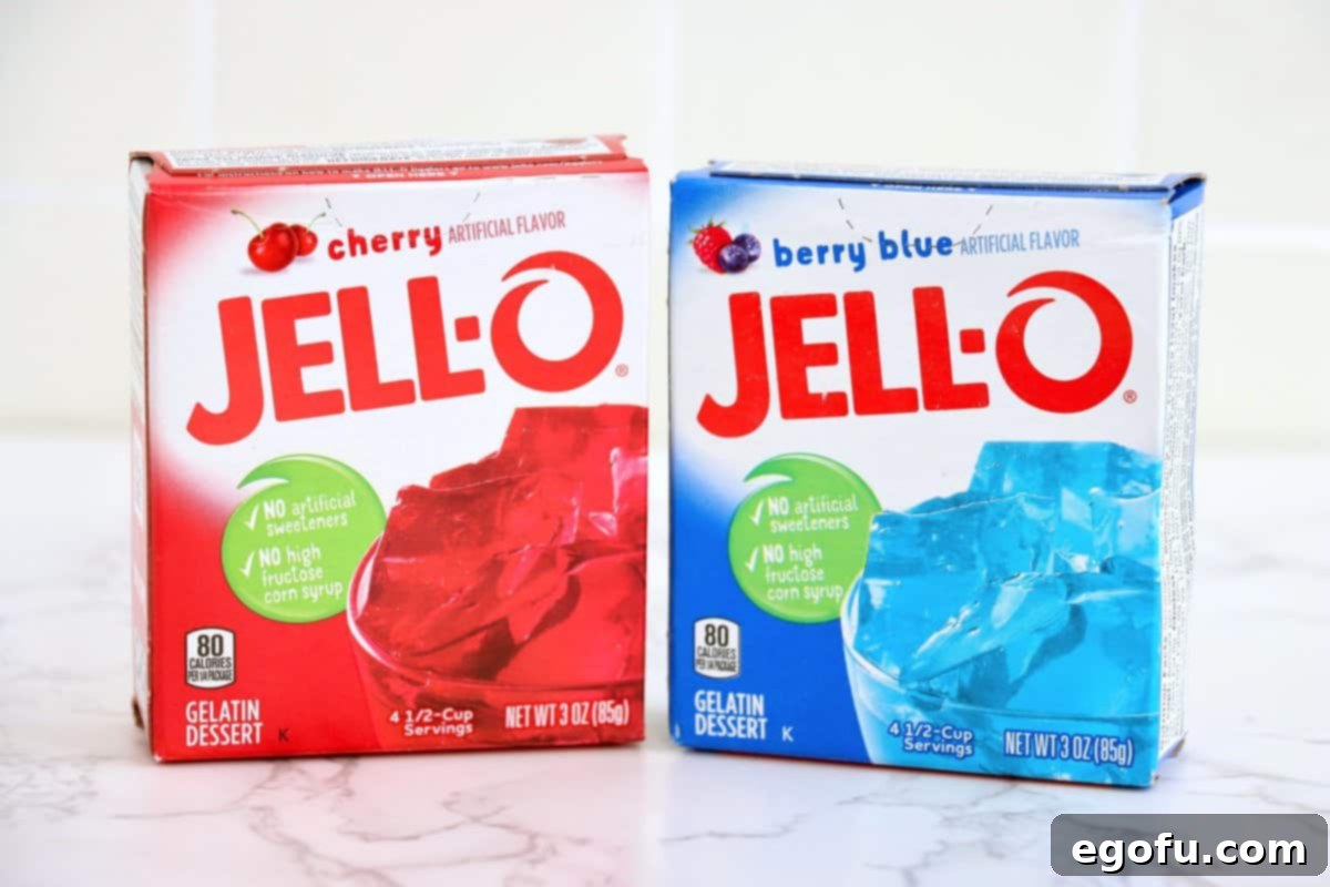 Festive Tri-Color Jell-O Cups 3 A box of cherry Jell-O and a box of Berry Blue Jell-O, ready for use.