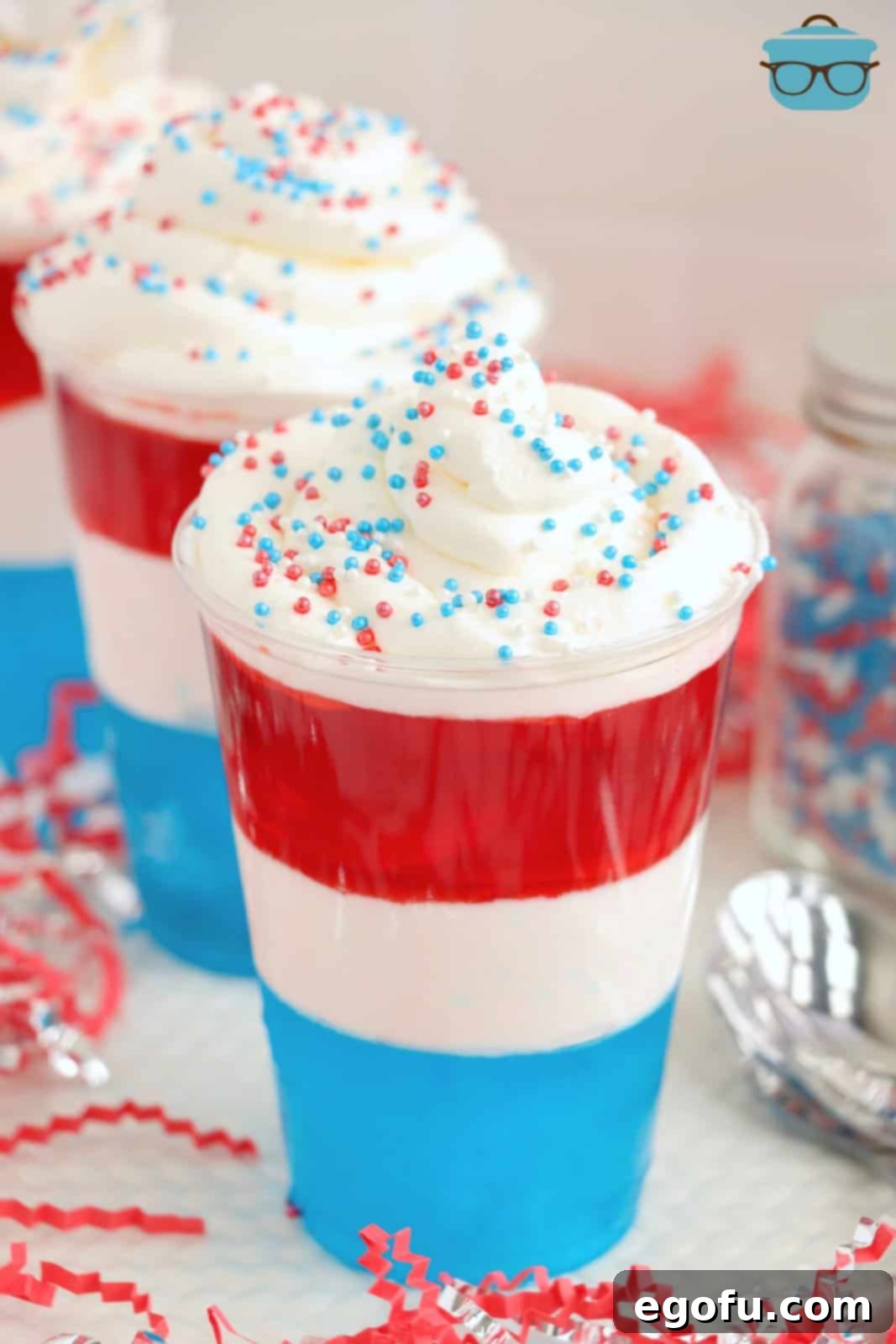 Festive Tri-Color Jell-O Cups 10 Layered Jello cups that are red, white, and blue, topped with whipped cream and sprinkles.
