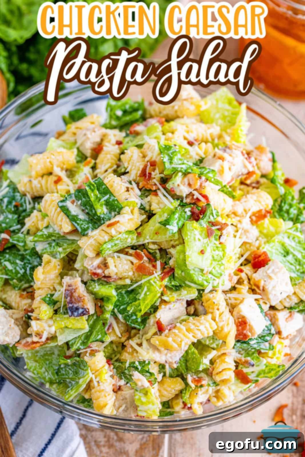 Large glass bowl brimming with freshly mixed Chicken Caesar Pasta Salad, ready to serve.