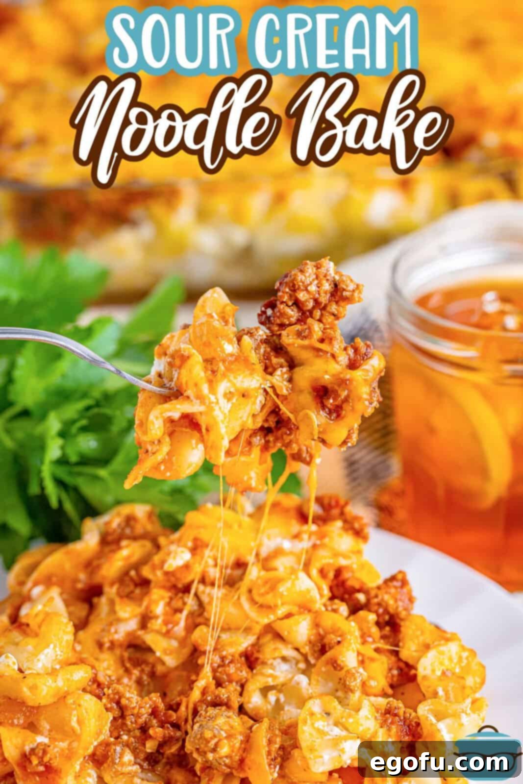 Creamy Baked Noodle Delight 3 A fork with a bite of Sour Cream Noodle Bake, showing the layers of noodle, meat, and cheese.