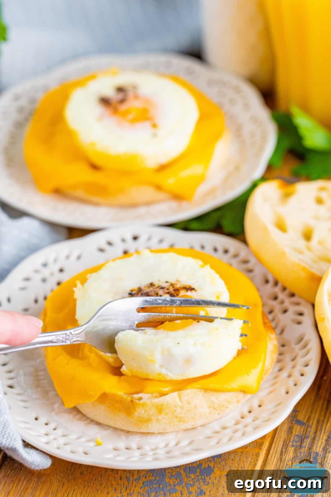 A perfectly baked egg, nestled on an English muffin with melted cheese, ready to be enjoyed.