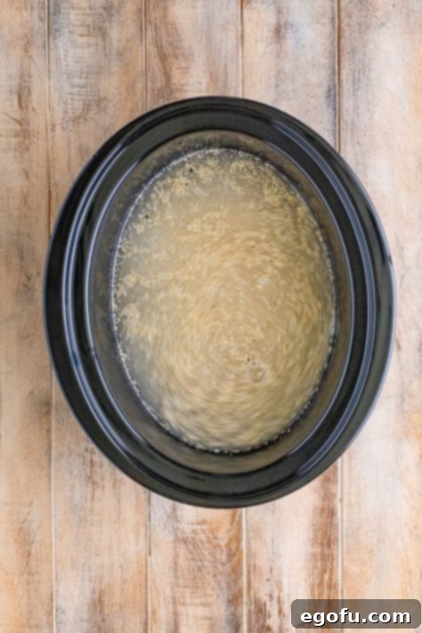 Grits, water, salt, and black pepper in a crock pot, prior to cooking.