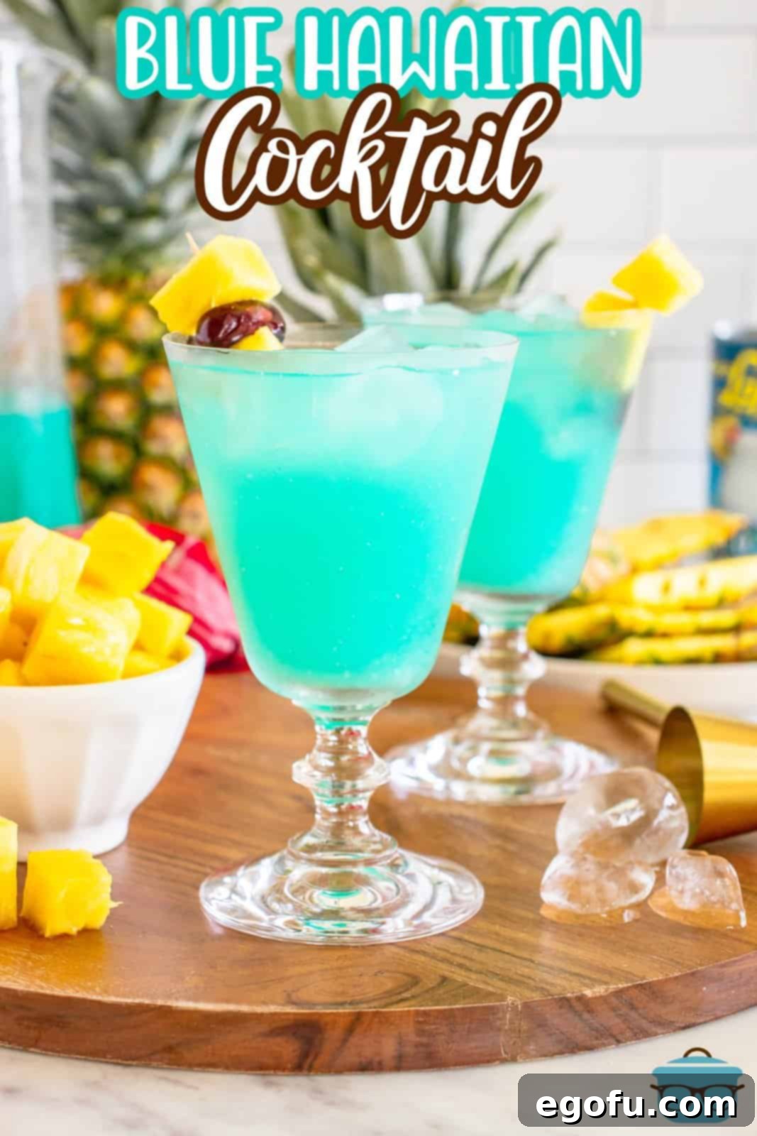 A single Blue Hawaiian cocktail in a tall glass, garnished with a pineapple wedge and cherry, sparkling in the light.