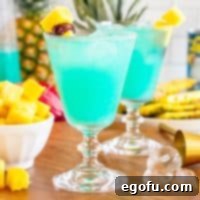 A few Blue Hawaiian Cocktails with garnishes around, ready to be served.