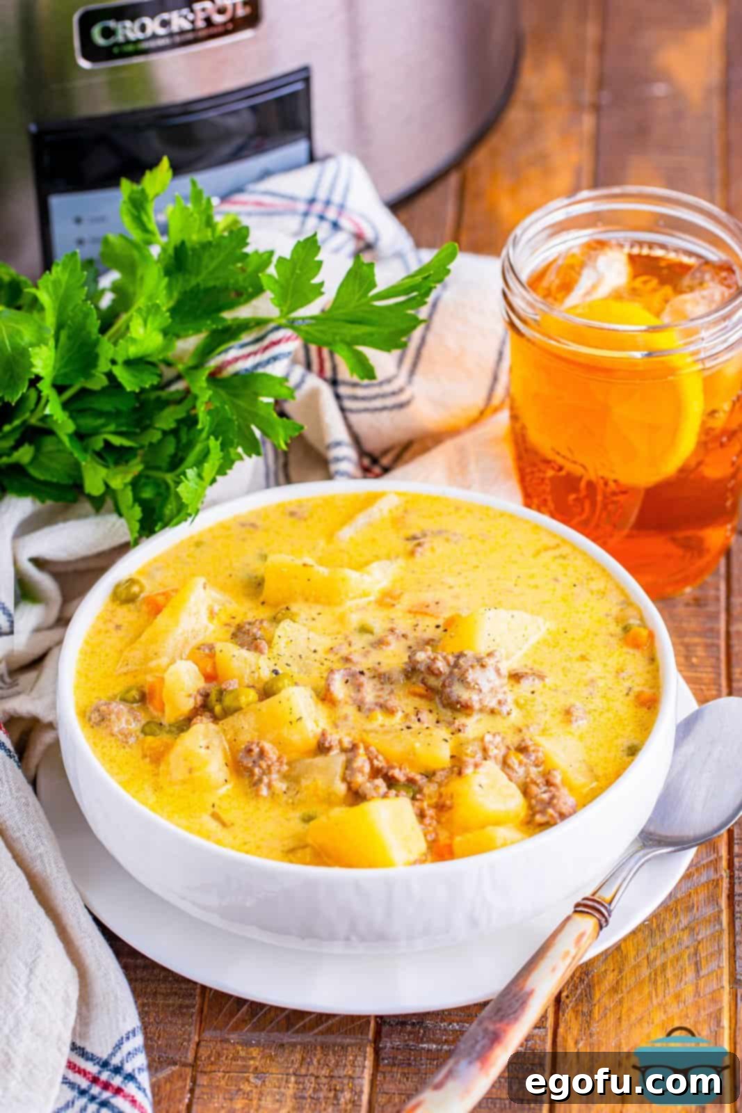 A bowl of Slow Cooker Hamburger Potato Soup, garnished with fresh herbs.