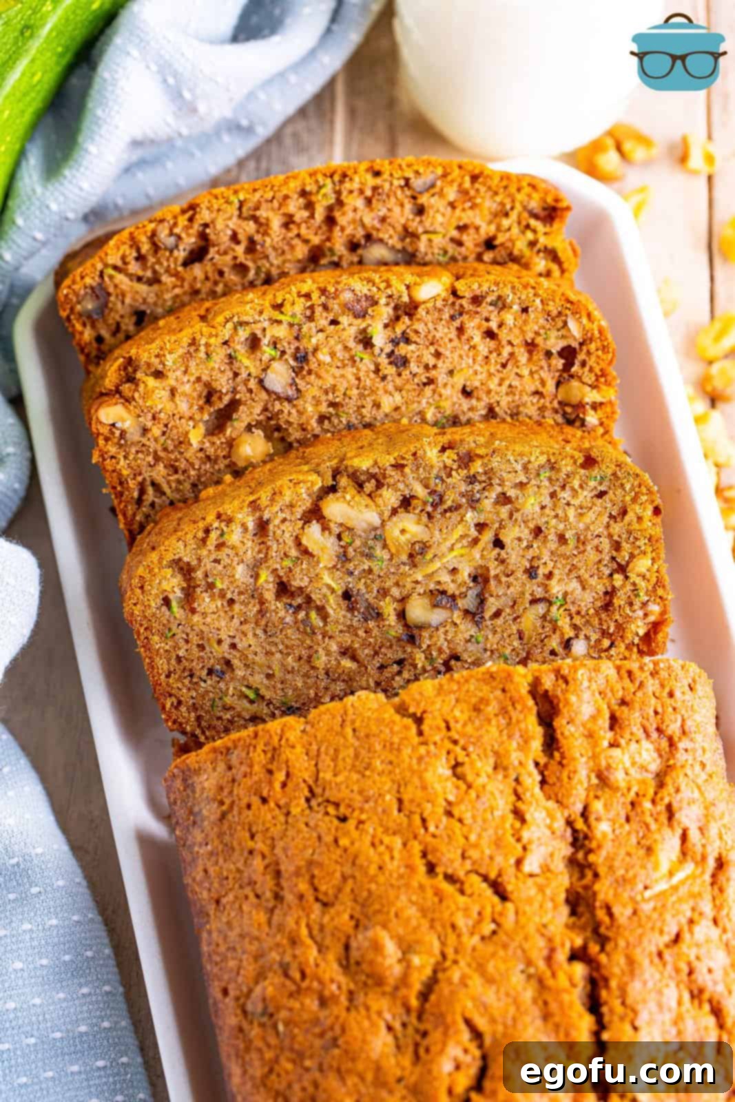 Looking down on a loaf of golden-brown Zucchini Bread that has a few slices already cut off, revealing its moist interior.