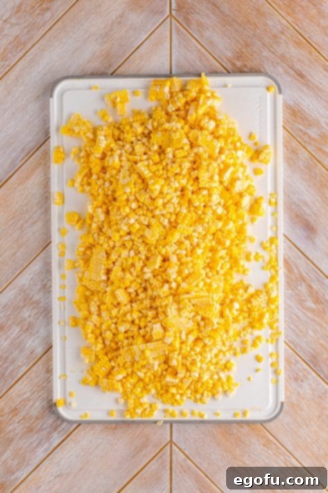 A cutting board with corn kernels.