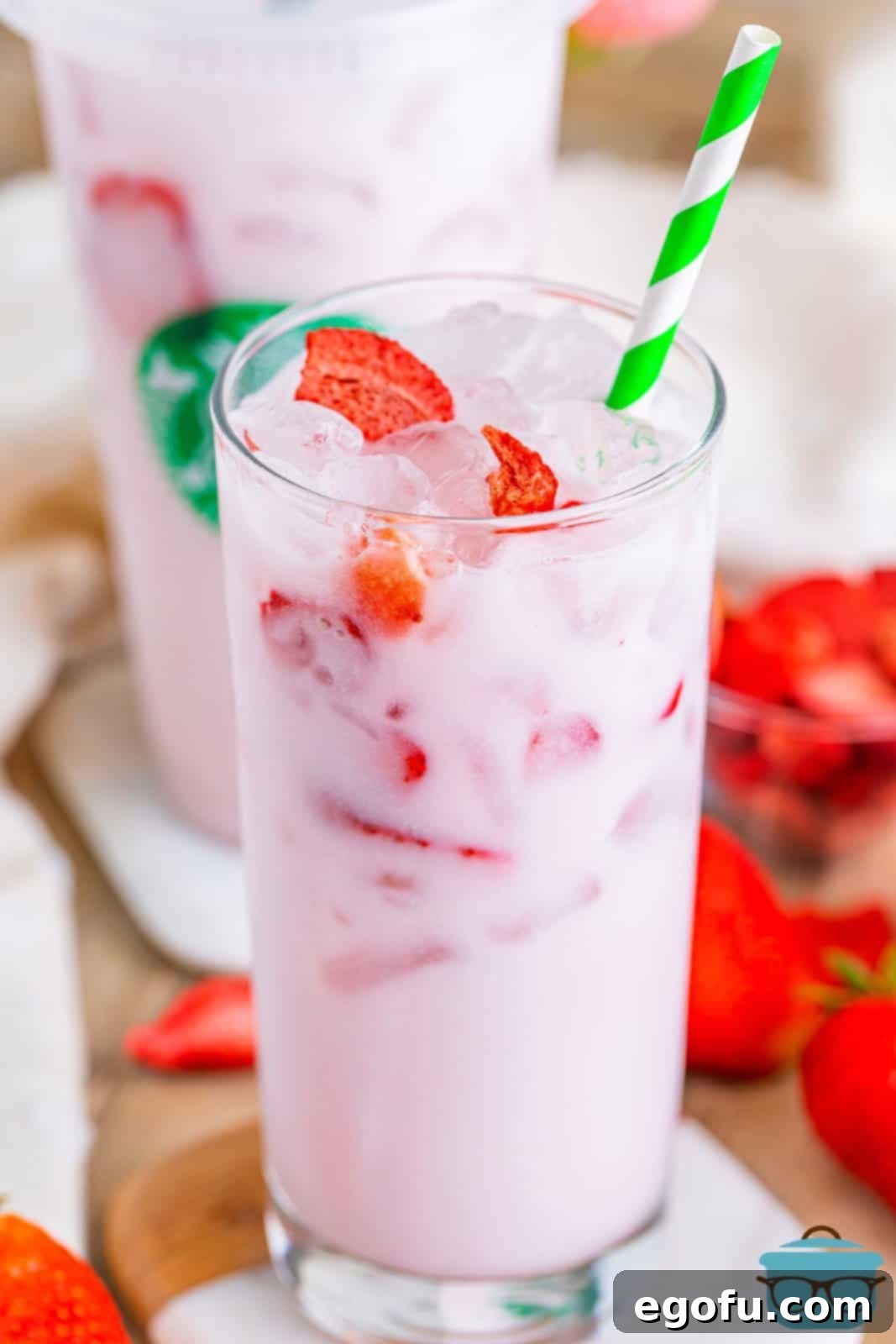 Starbucks' Iconic Pink Drink 2 A glass with Pink Drink and freeze dried strawberries.