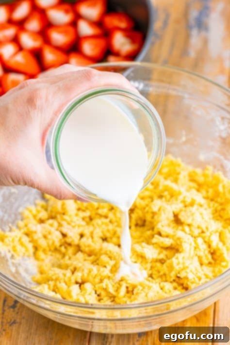 Milk being added to the cake batter mixture.