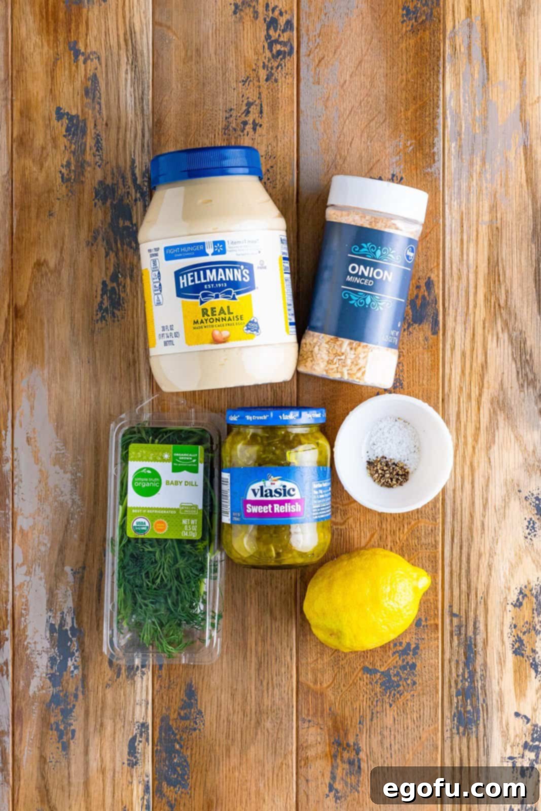 Tangy Homemade Tartar Sauce 5 Individual ingredients laid out: mayonnaise, lemon juice, fresh dill, sweet pickle relish, dried minced onion, kosher salt, and black pepper.