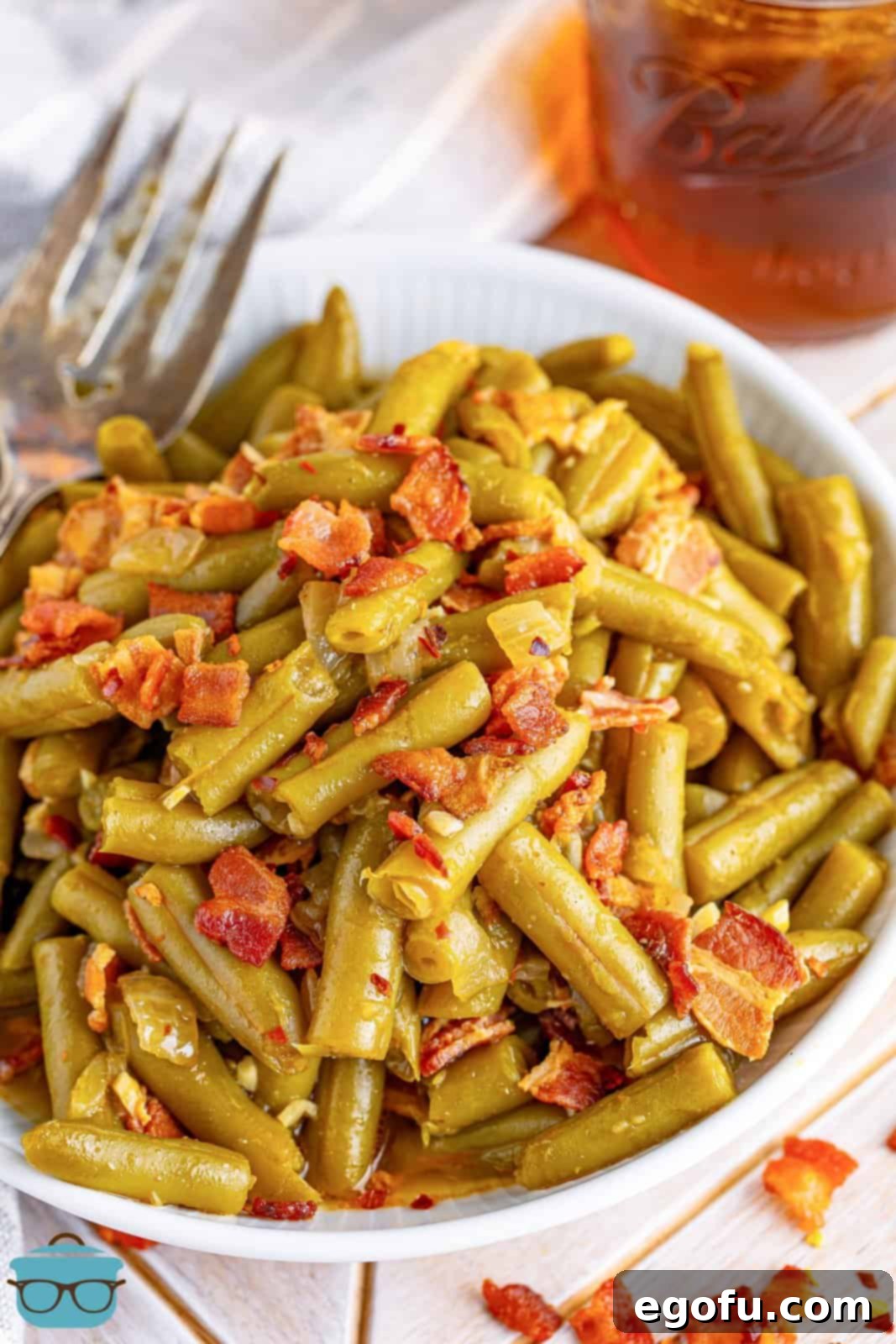 A beautifully plated serving of slow cooker green beans, garnished with crispy bacon bits, ready to be enjoyed.