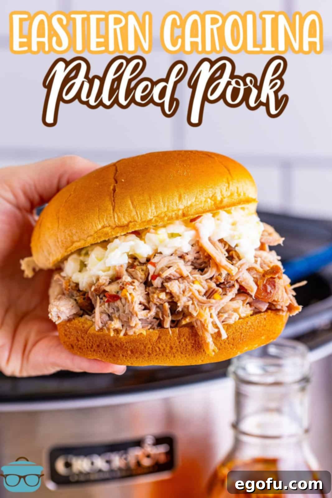 Classic Crock Pot Eastern Carolina Pulled Pork 3 A hand holding an Eastern Carolina Pulled Pork sandwich.
