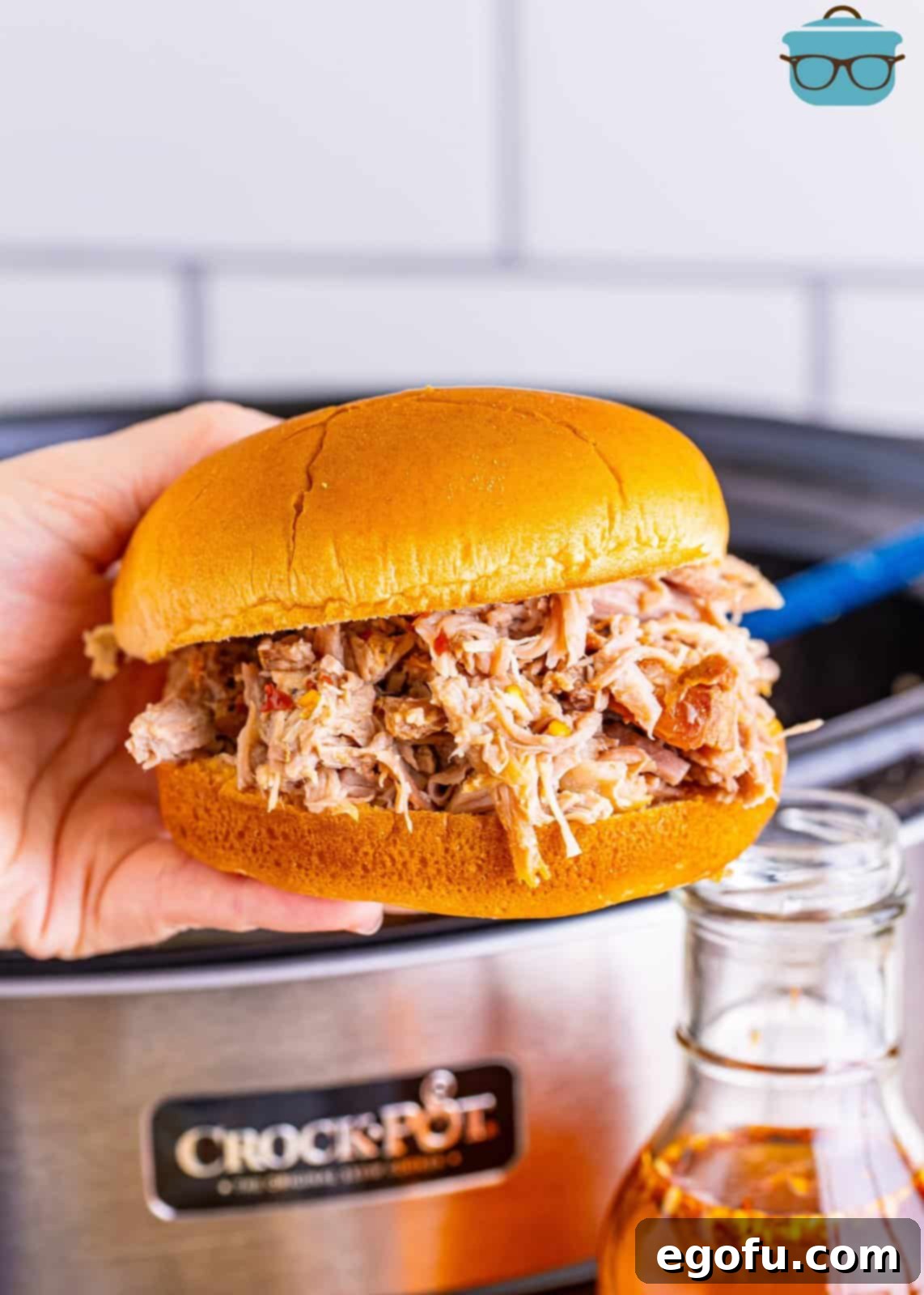 Classic Crock Pot Eastern Carolina Pulled Pork 8 A hand holding a pulled pork sandwich.