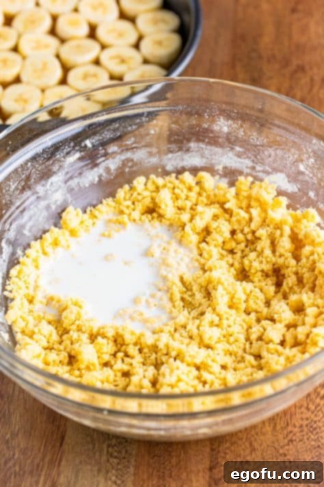 Milk being gently added to the cake batter mixture in a bowl, preparing for final mixing.