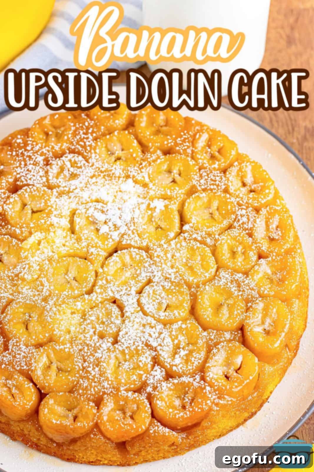 A golden-brown banana upside down cake resting in a round baking dish, cooling after being removed from the oven.
