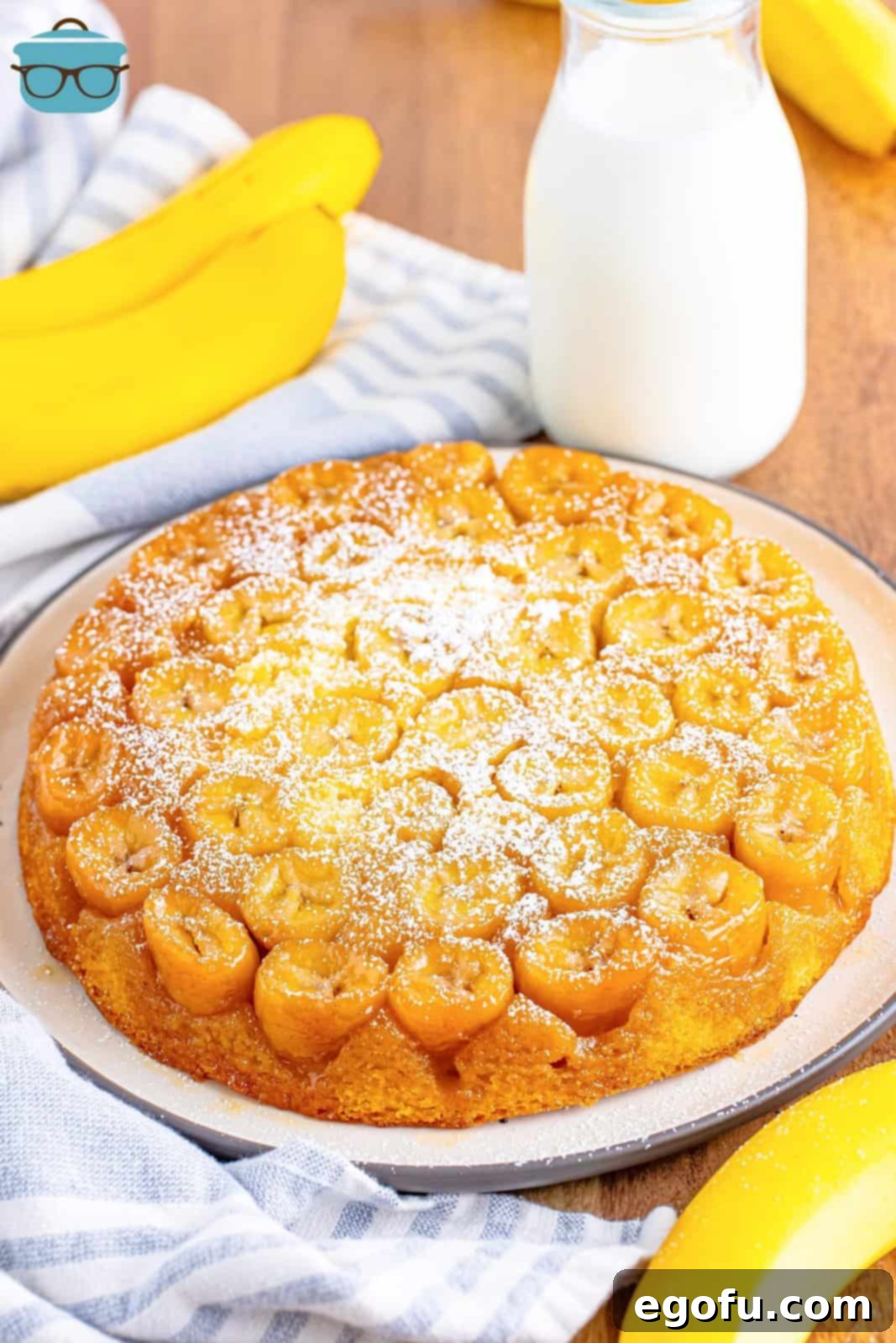 A stunning banana upside down cake, perfectly inverted, sits on a pristine white serving platter, showcasing its caramelized banana topping.