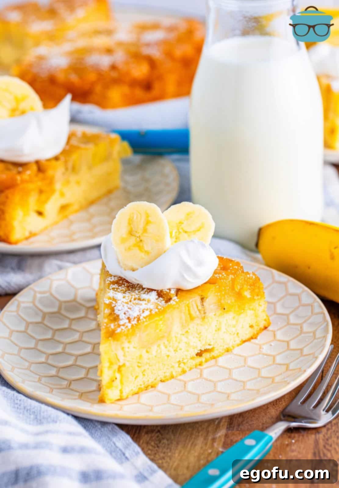 A single slice of moist banana upside down cake served on a white plate, revealing the golden caramelized banana topping.