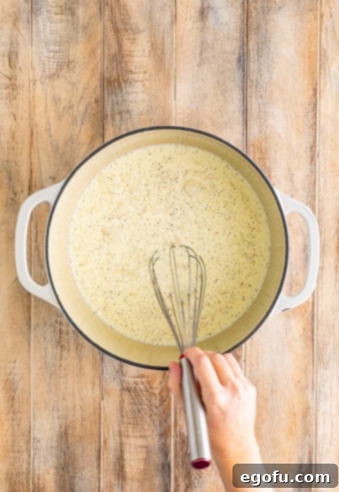 Bayou Bounty Shrimp and Grits 11 A dutch oven with chicken broth, cream, grits, salt, and pepper.