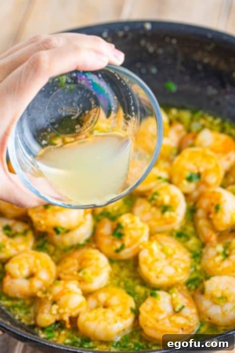 Bayou Bounty Shrimp and Grits 16 Lemon juice being poured into a pan of cooked shrimp.