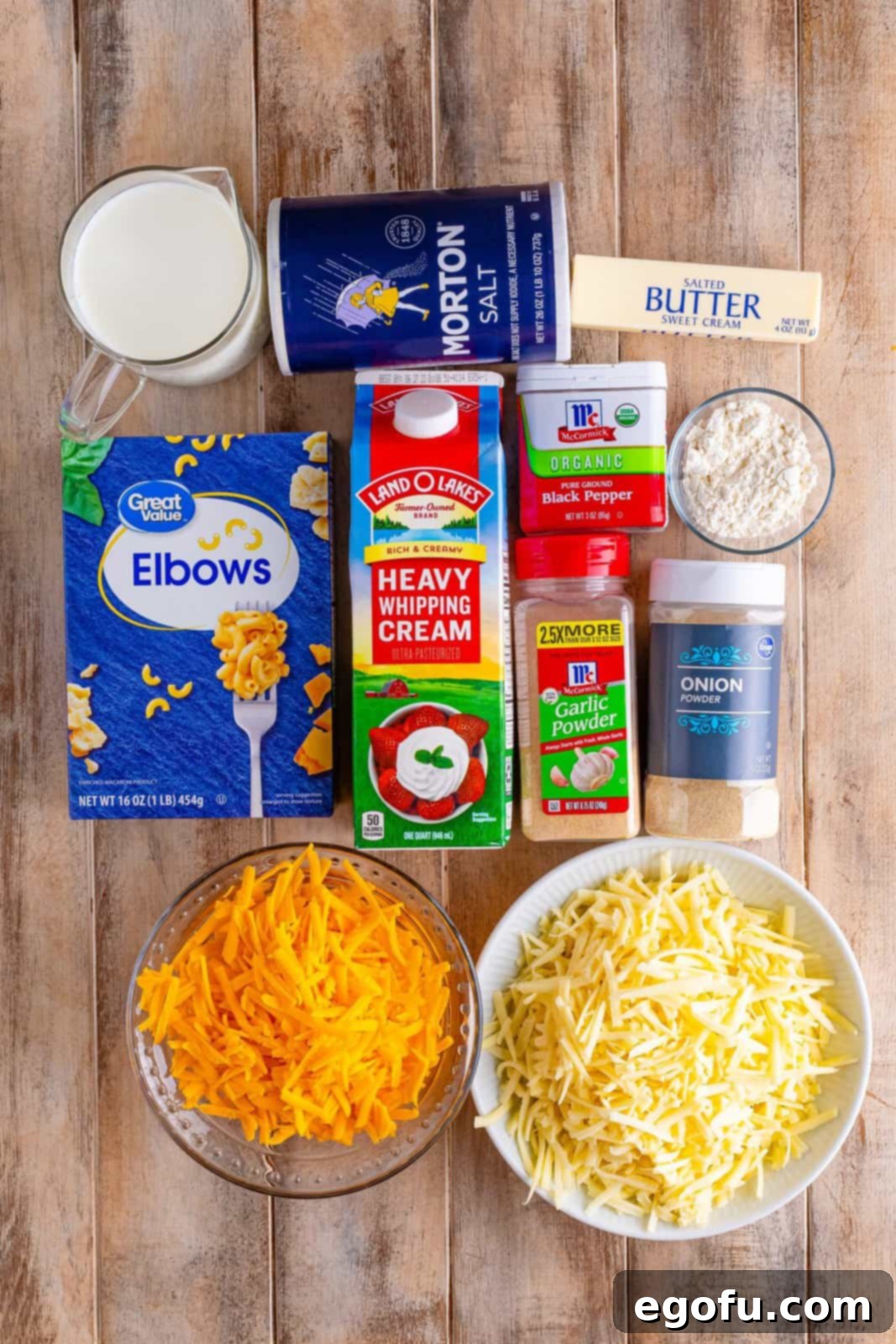 Golden Crusted Macaroni 4 A beautiful flat lay of all the essential ingredients for Baked Mac and Cheese: elbow macaroni, shredded sharp cheddar and Gruyere, heavy cream, whole milk, onion powder, garlic powder, salt, butter, flour, and black pepper.