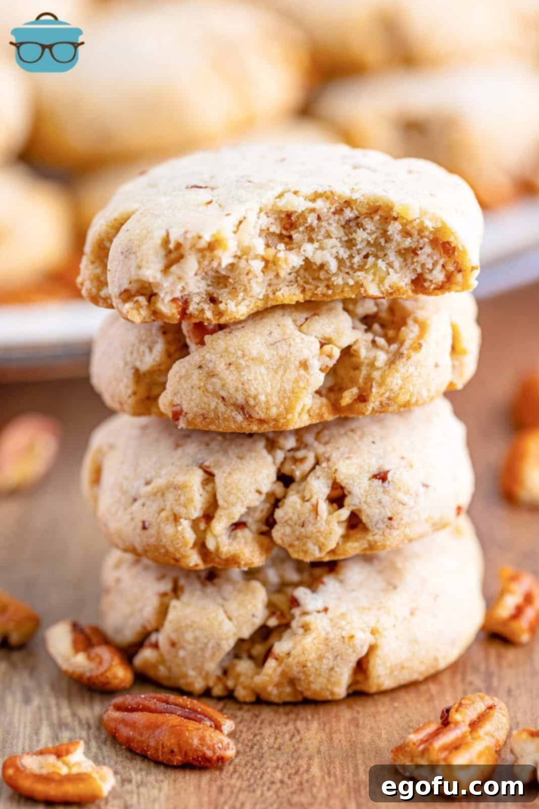 A beautifully arranged stack of golden-brown Pecan Sandies, with one cookie showing a delicate bite taken, highlighting its crumbly texture.