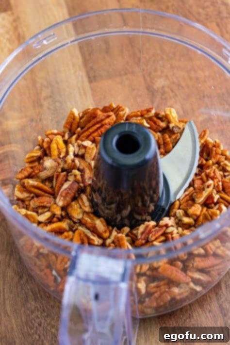 Finely pulsed pecans in a food processor, ready to be added to the cookie dough.