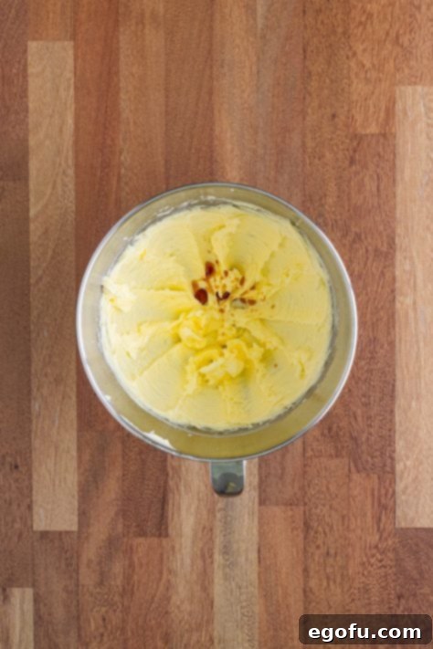 Vanilla extract being added to the butter and sugar mixture.