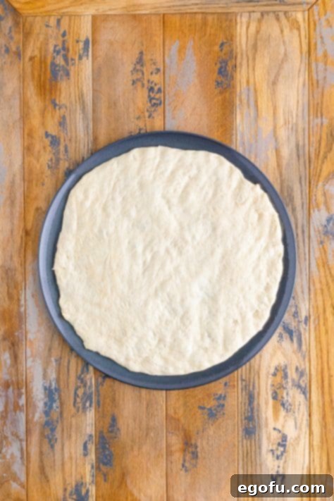 Pizza dough on a pizza pan.