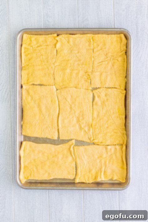 Savory Chicken Pockets 11 A baking sheet with crescent roll dough pinched together.