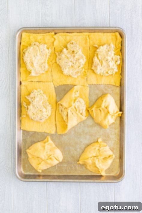 Savory Chicken Pockets 13 Some of the chicken bundles being packaged up on a baking sheet.