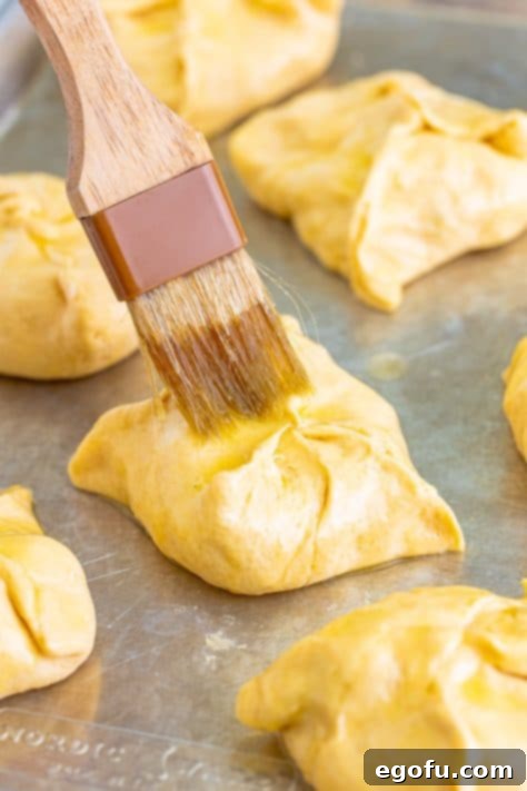 Savory Chicken Pockets 14 Butter being brushed on the chicken bundles.