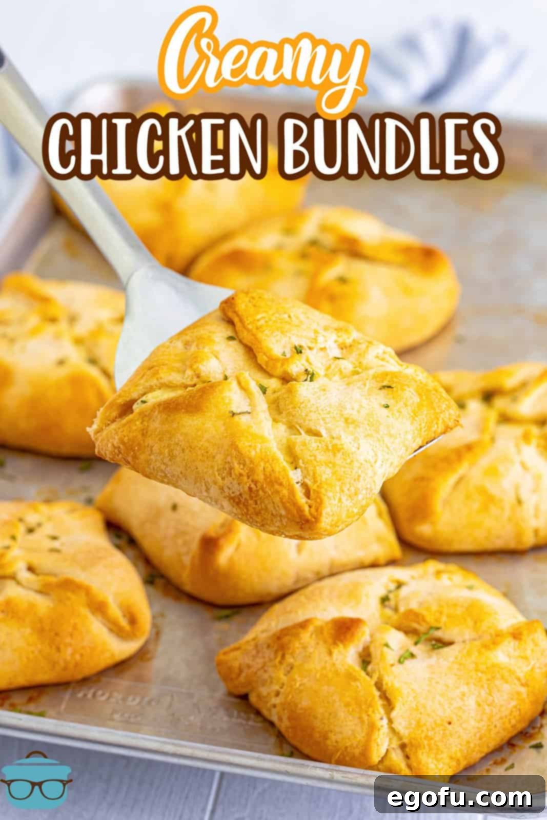 Savory Chicken Pockets 3 A serving spatula holding a Chicken Bundle above a platter of them.