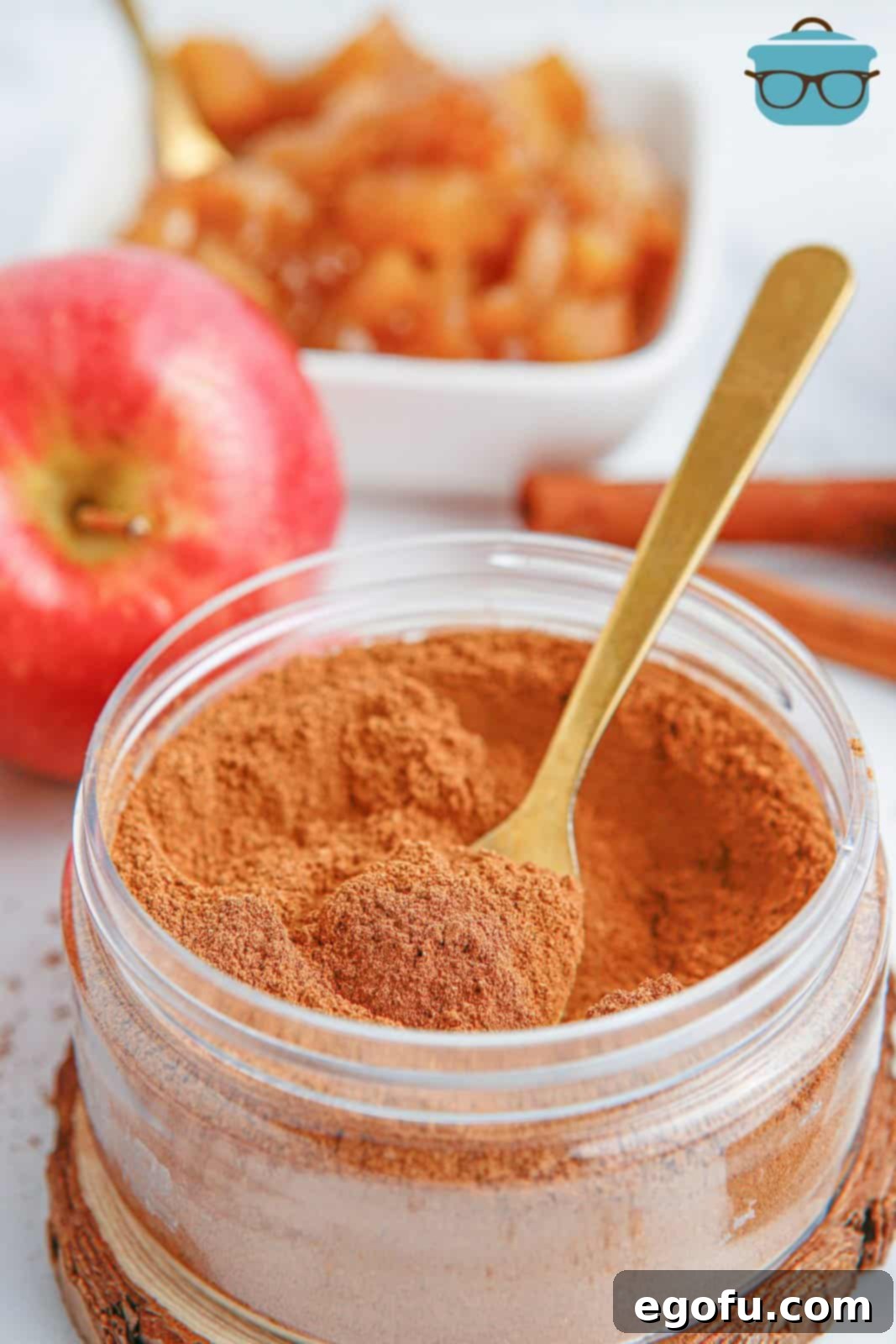 A spoon in a container of homemade Apple Pie Spice, showing its texture and readiness for use.
