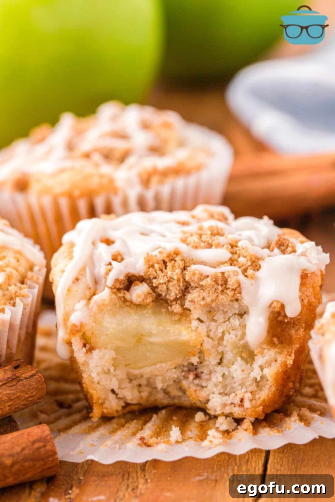 An Apple Streusel Muffin with a bite taken out, showcasing the tender apple pieces and crumbly streusel topping.